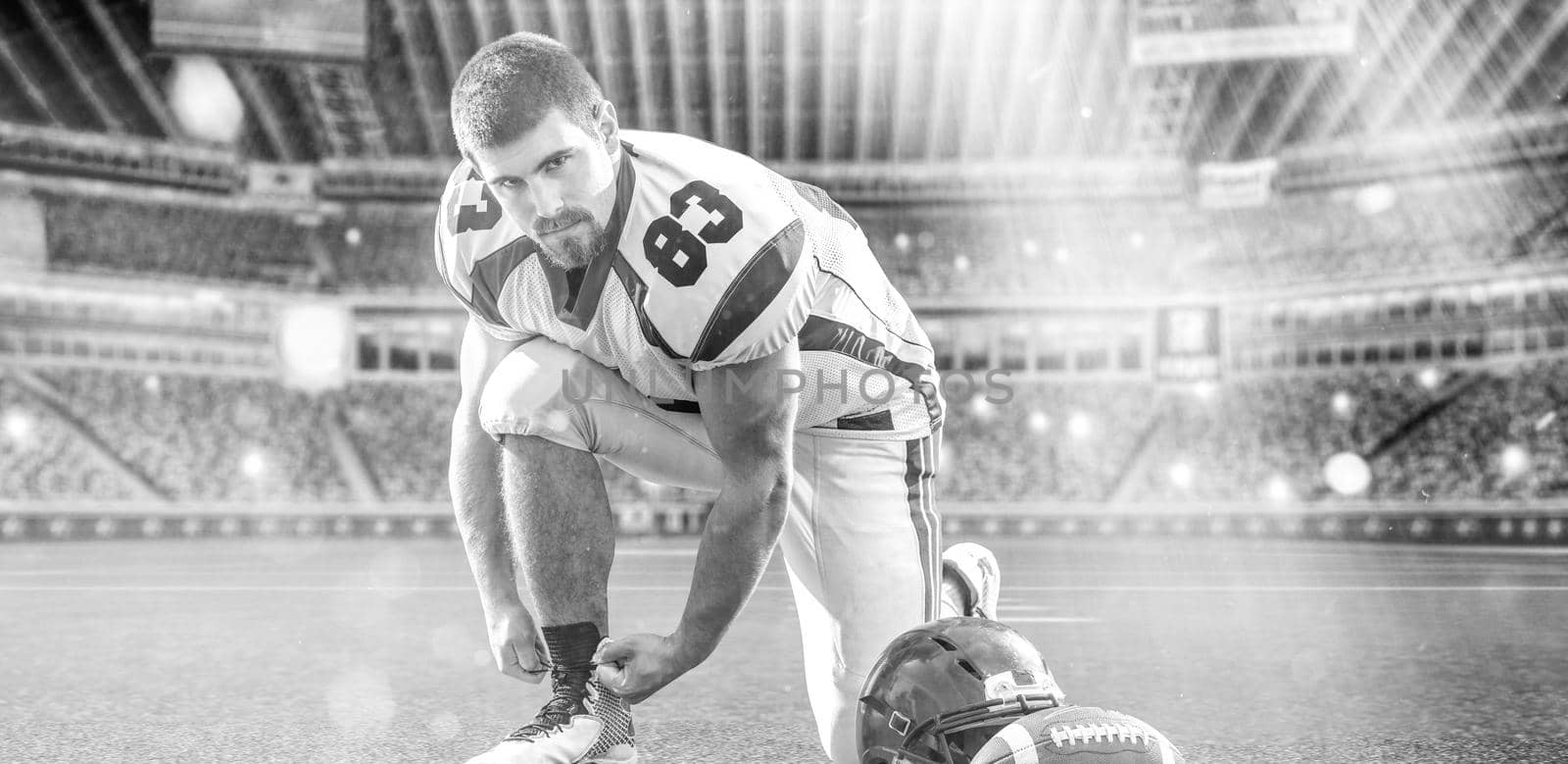 American Football Player preparing for match on big modern stadium field with lights and flares