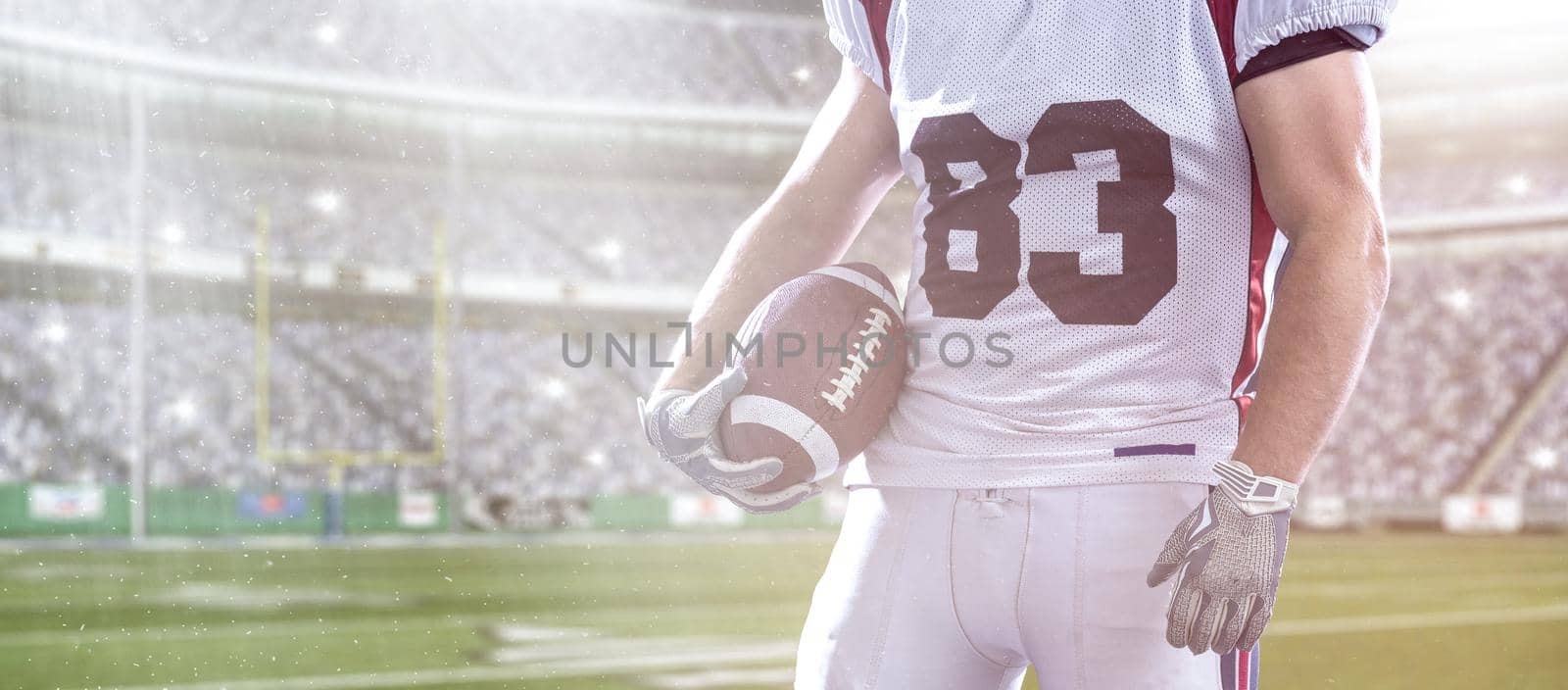 Closeup Portrait of a strong muscular American Football Player on big modern stadium field with lights and flares