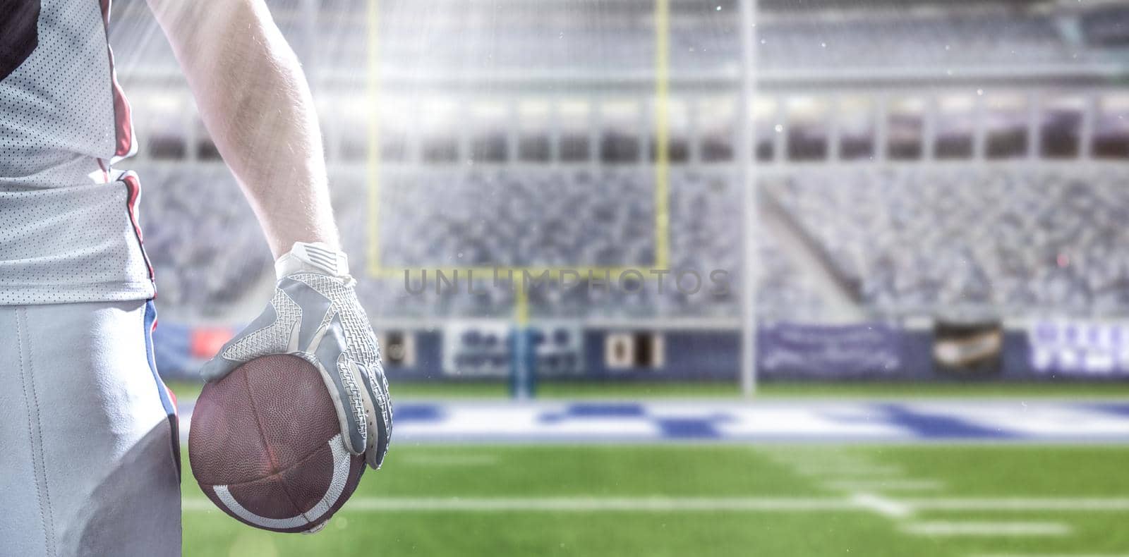 Closeup Portrait of a strong muscular American Football Player on big modern stadium field with lights and flares