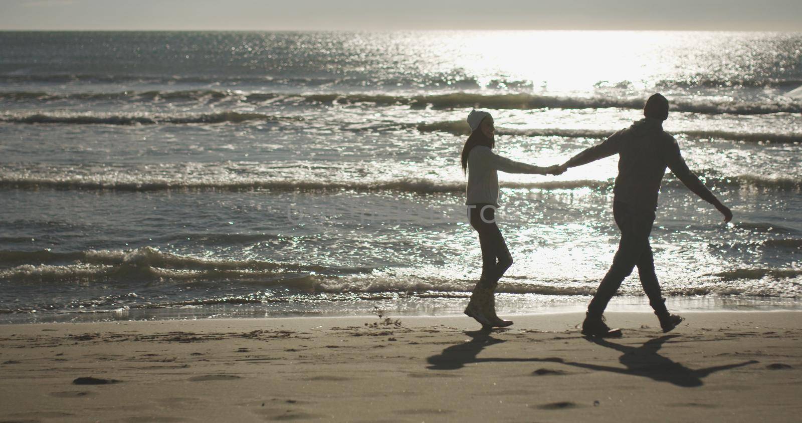 Romantic Couple Relaxing On The Beach during autumn day