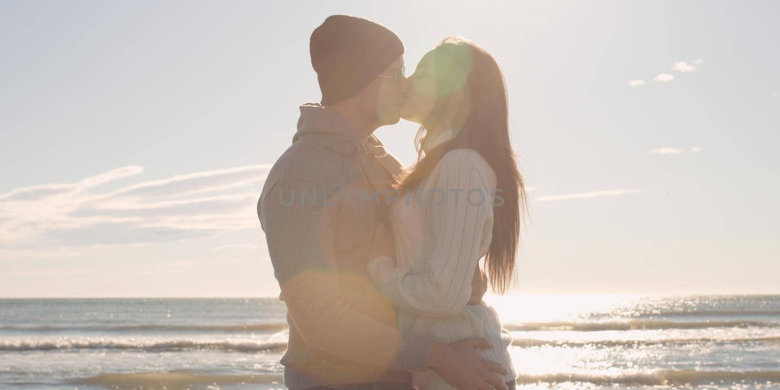 Cool Couple Laughing and hugging In Front Of Beach at beautiful autumn day