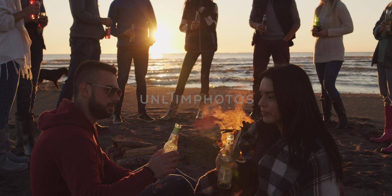Friends having fun at beach on autumn day by dotshock