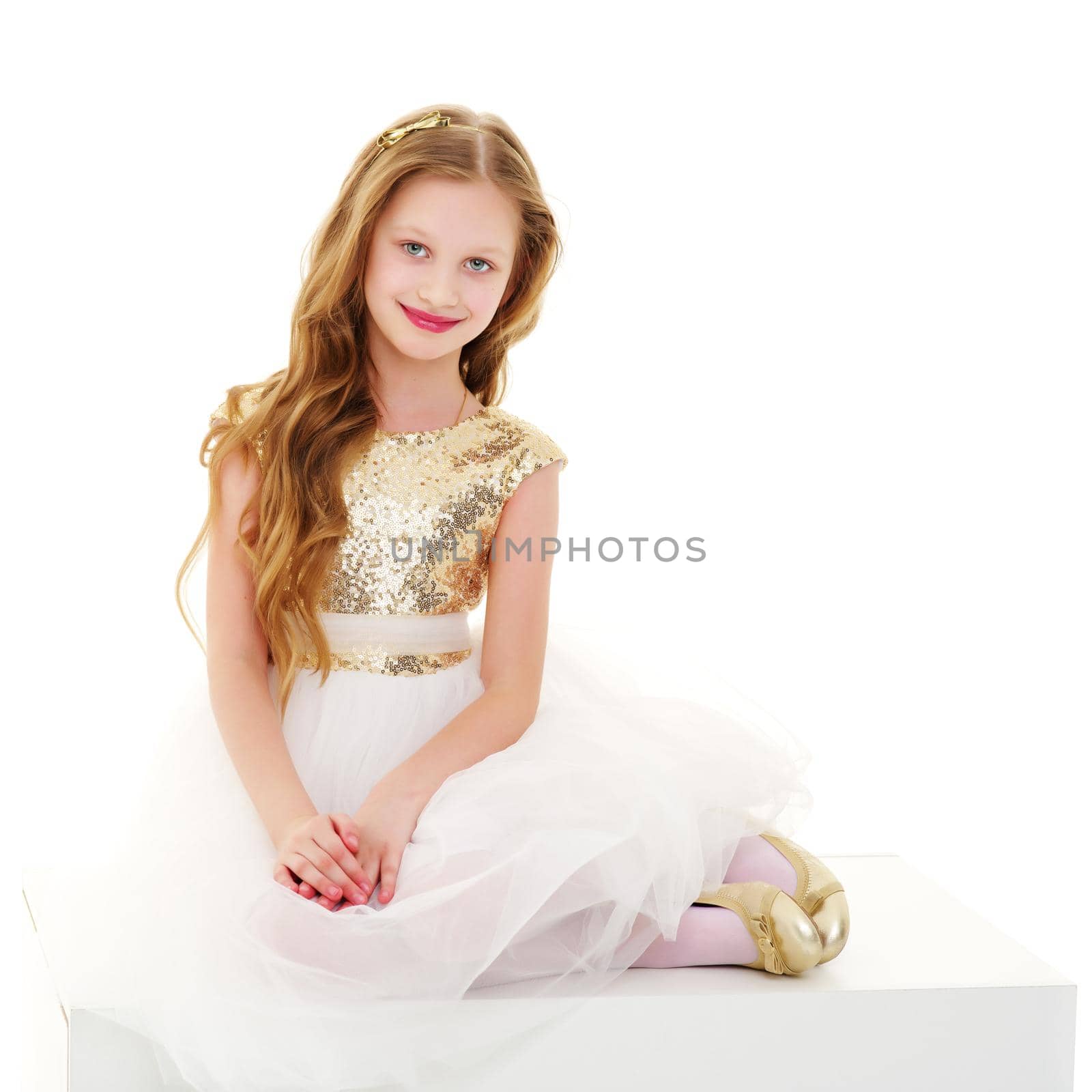 Cheerful little girl sitting on a white banner on which to write the inscription. The concept of advertising products and services. Isolated on white background