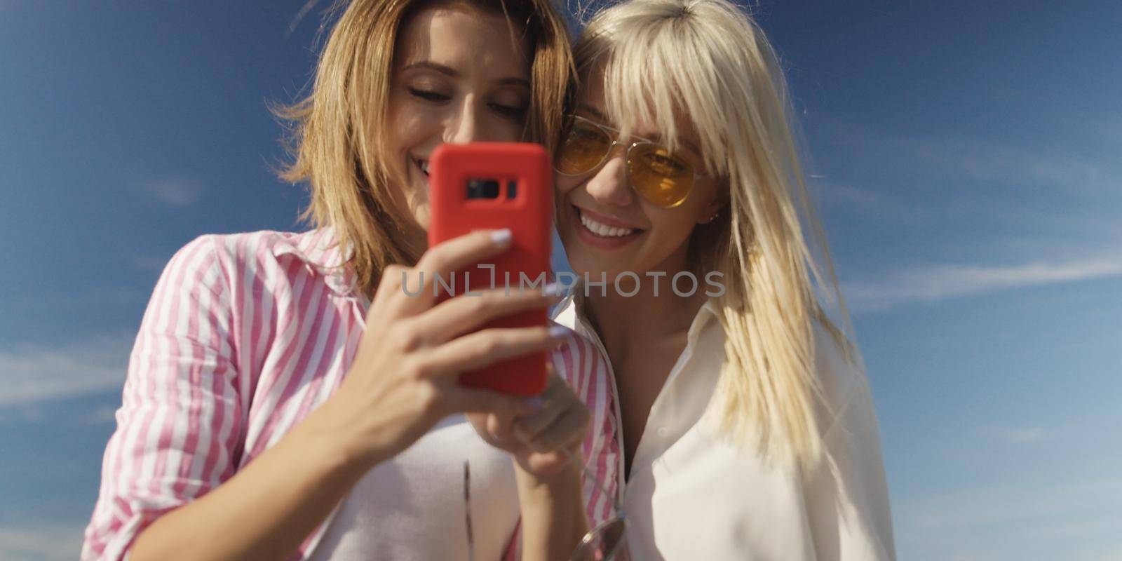 Two girl friends having fun photographing each other on vecation by dotshock