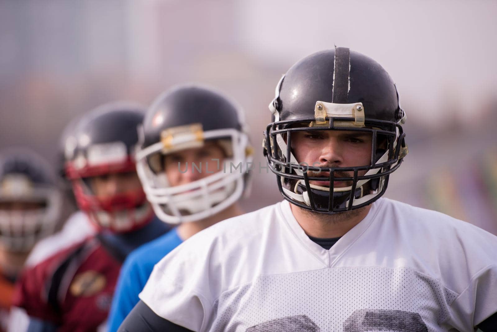 portrait of young american football team standing one behind the other on field