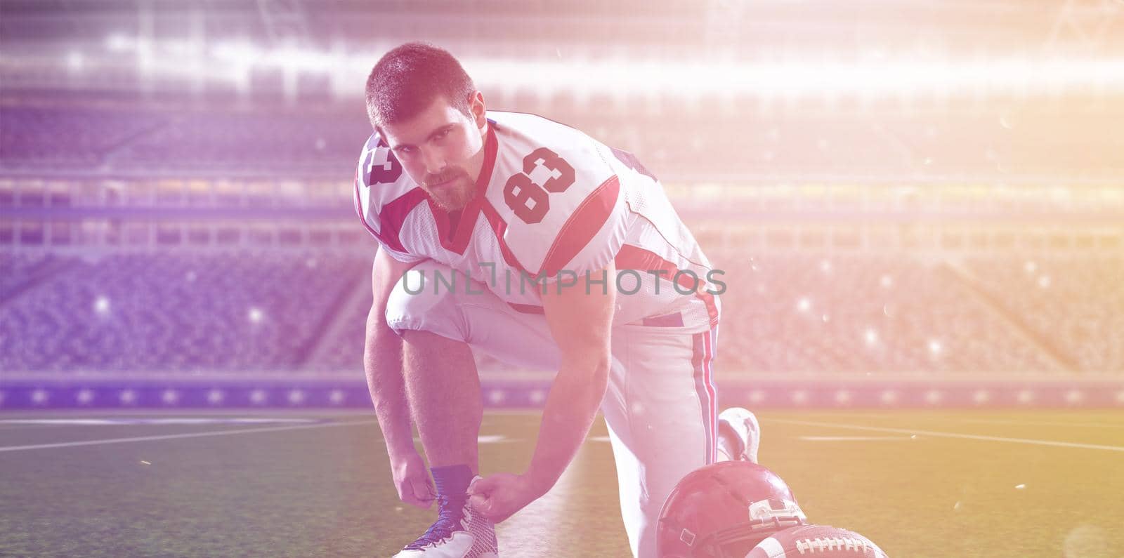 American Football Player preparing for match on big modern stadium field with lights and flares