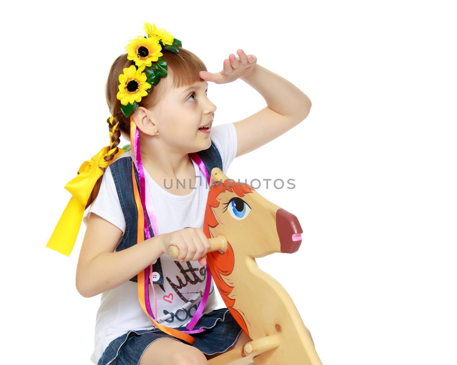 Little girl swinging on a wooden horse. by kolesnikov_studio