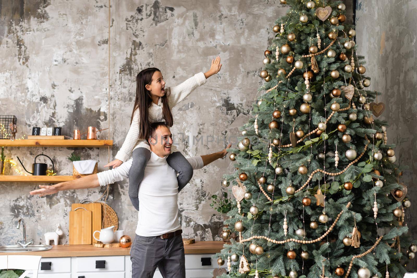 Merry Christmas and happy Holidays. Mom, dad and daughter decorating christmas tree