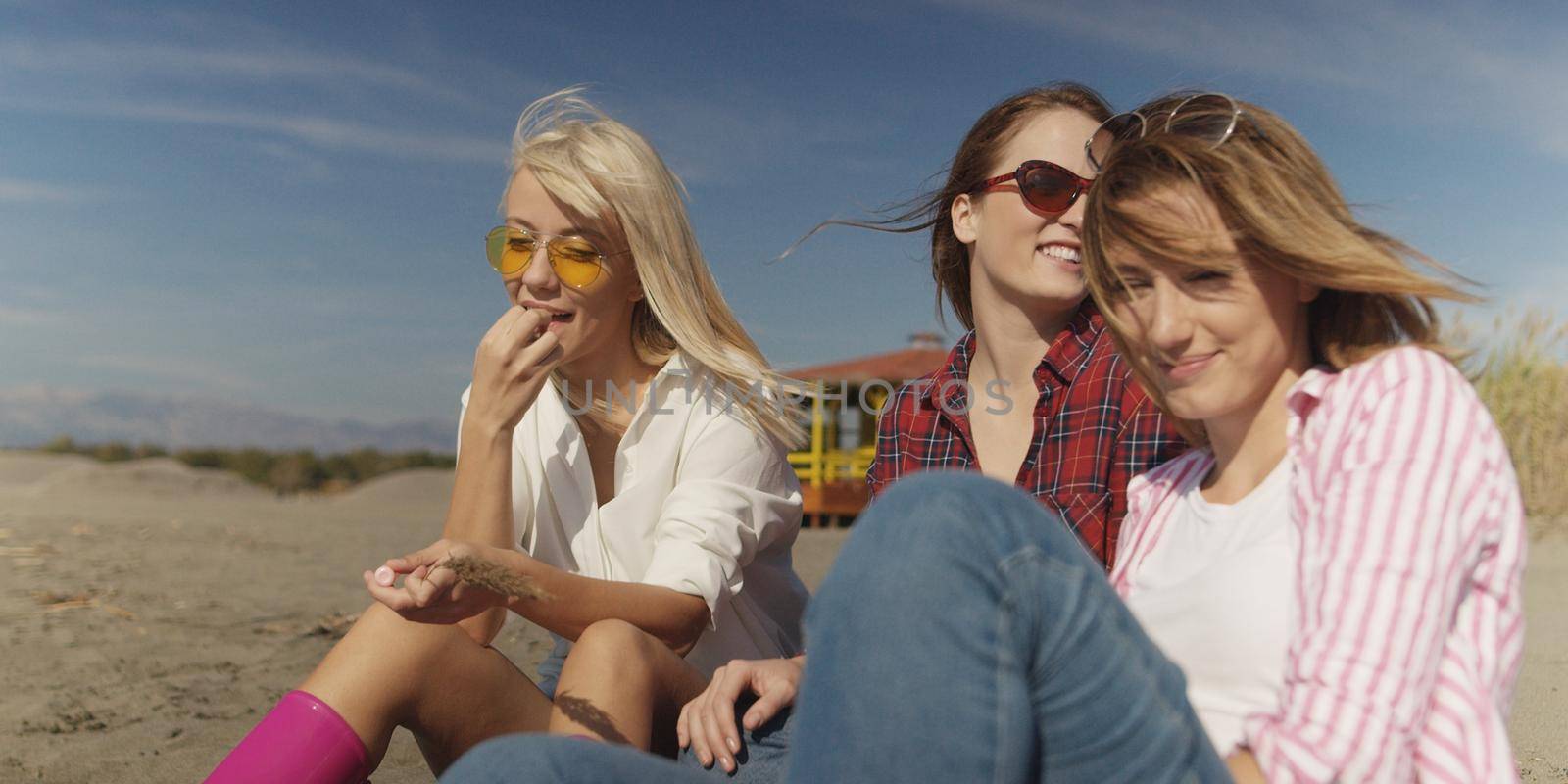 Group Of Young girlfriends Spending The Day On A Beach during autumn day