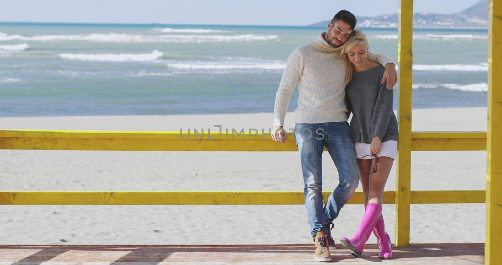 Happy couple enyojing time together on beach during autumn day