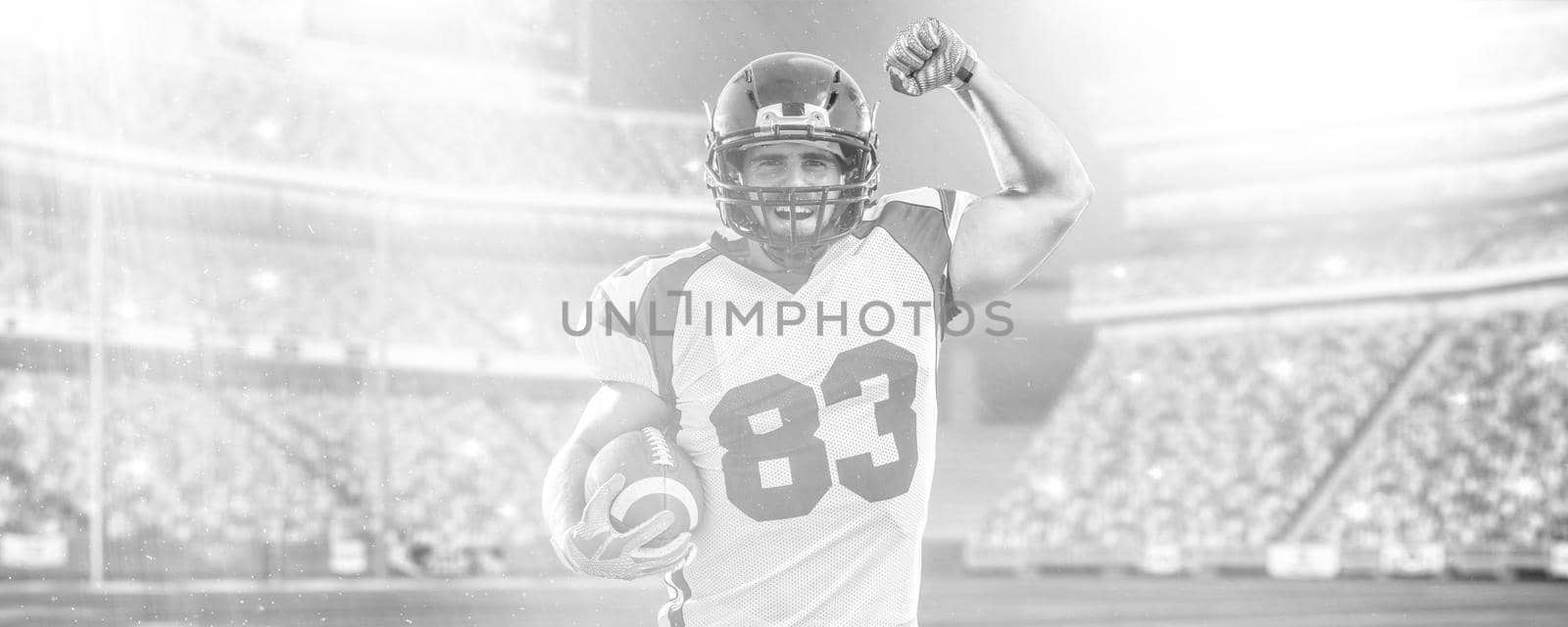 american football player celebrating touchdown on big modern stadium field with lights and flares