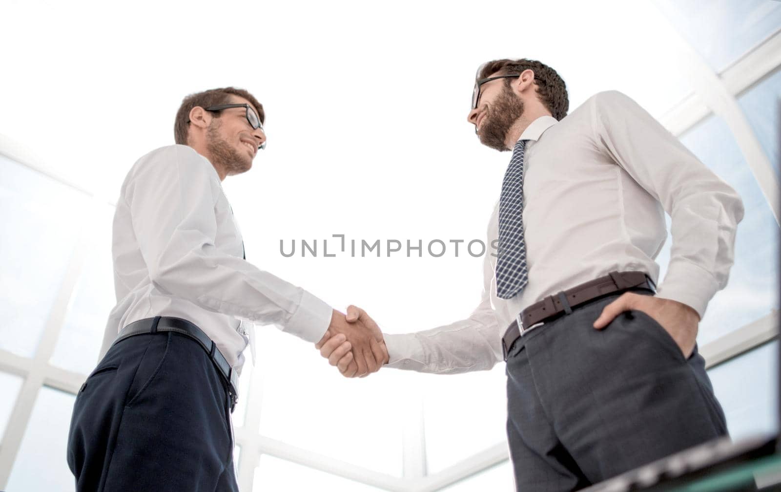 bottom view.handshake business partners standing in the office.concept of partnership