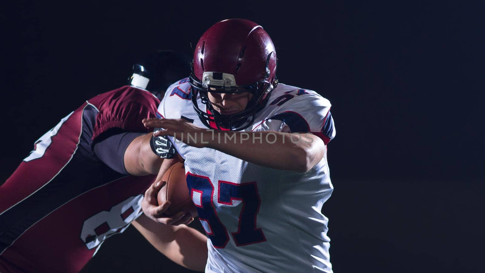 American football players in action at night game time on the field