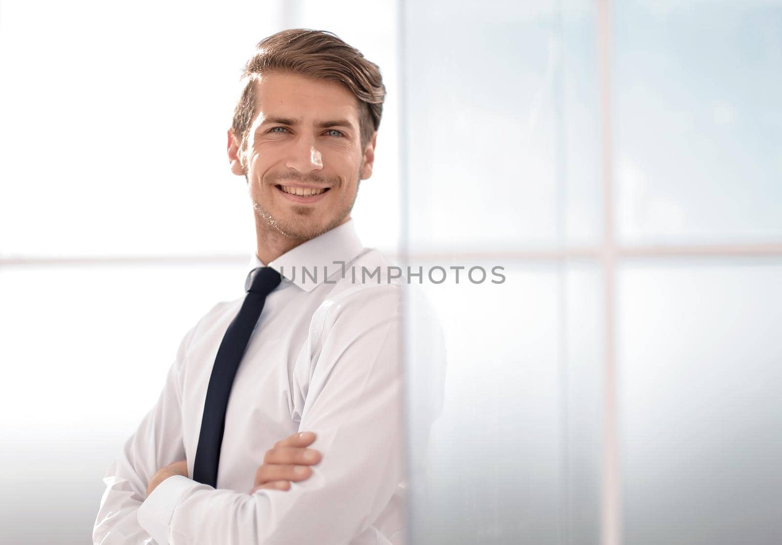 smiling businessman standing near the office window.business concept