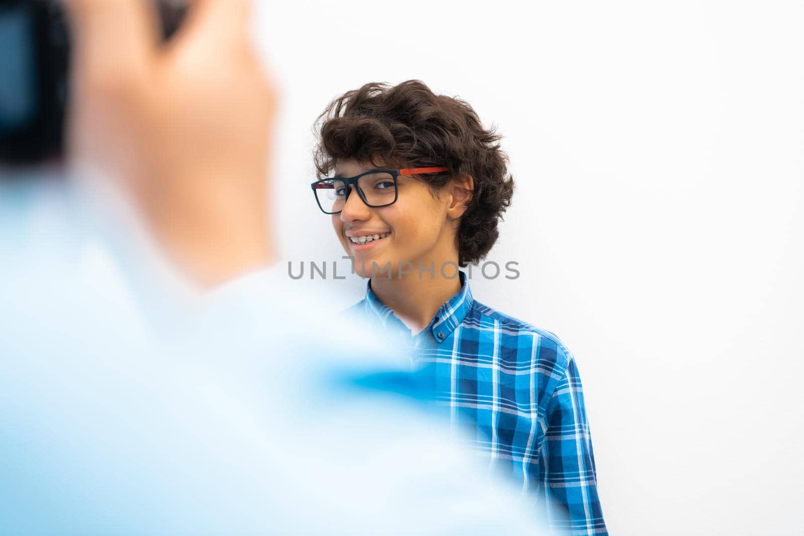 portrait of smart looking arab teenager with glasses wearing a hat in casual school look isolated on white copy space. High quality photo