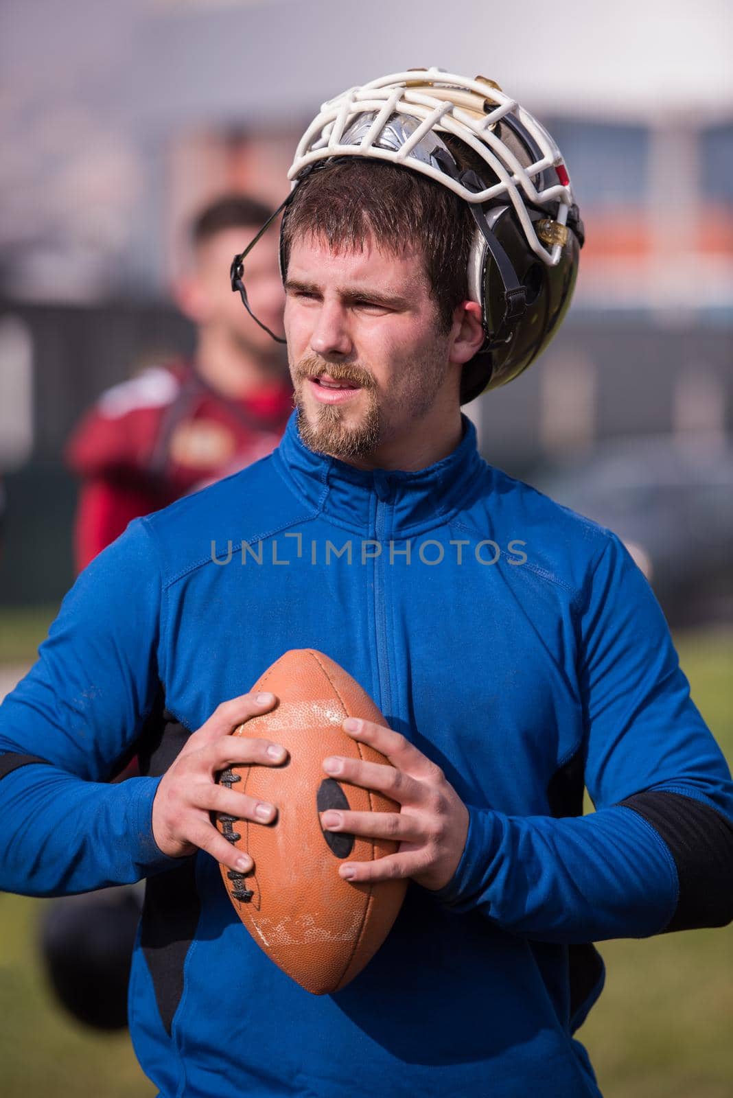 portrait of young confident American football player  standing on a field during the training