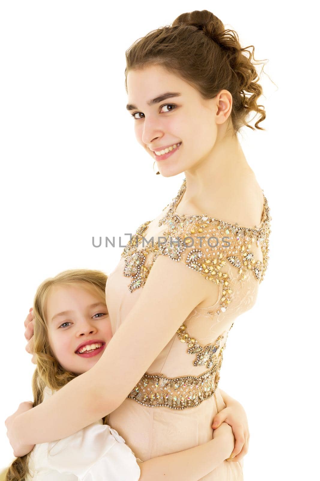 A young girl hugs her little sister. by kolesnikov_studio