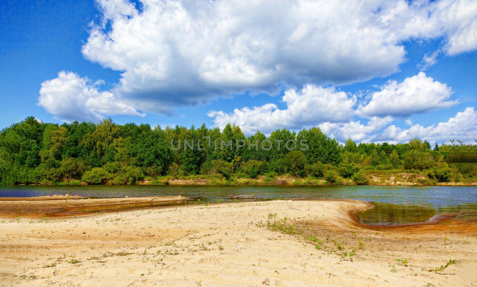 Wild sandy beach near the river on a fine summer day. Only blue sky, sand and a quiet river. Russia, Kostroma region, Kozionikha village. The concept of tourism, native land.