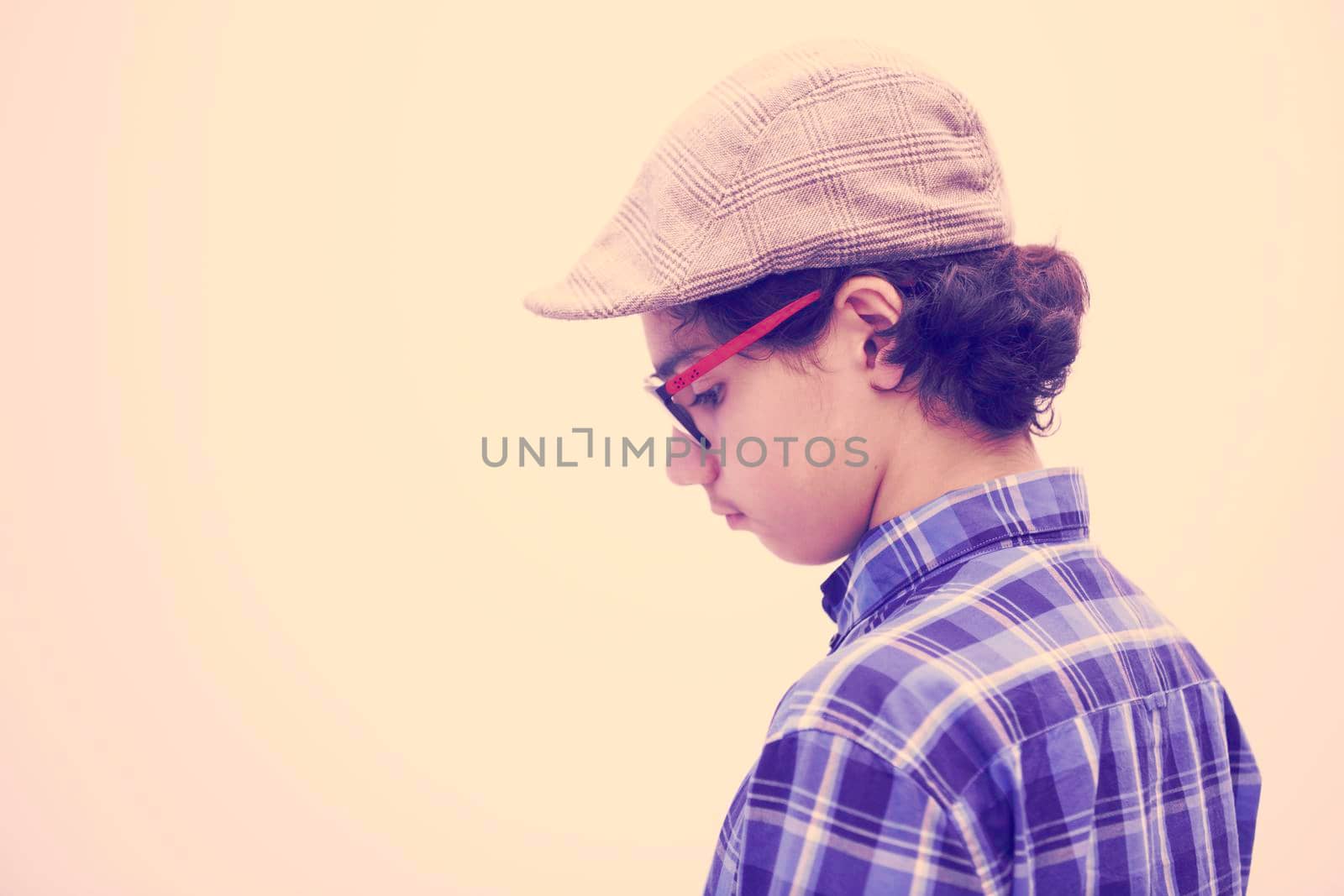 portrait  of smart looking arab teenager with glasses wearing a hat in casual school look isolated on white copy space