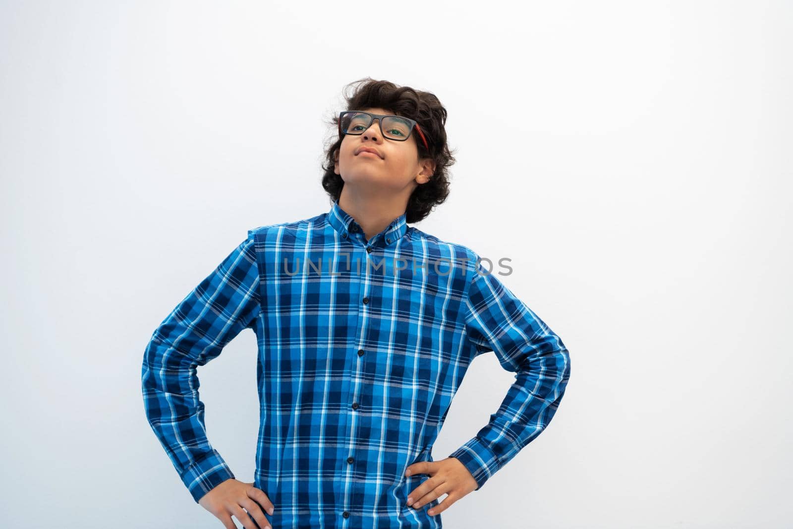 portrait of smart looking arab teenager with glasses wearing a hat in casual school look isolated on white copy space by dotshock