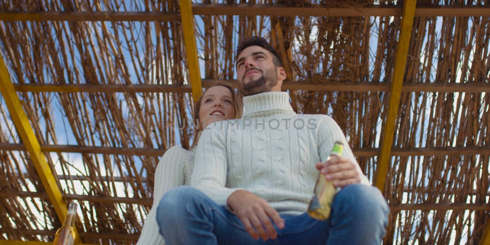 Couple Drinking Beer Together on beach during autumn time