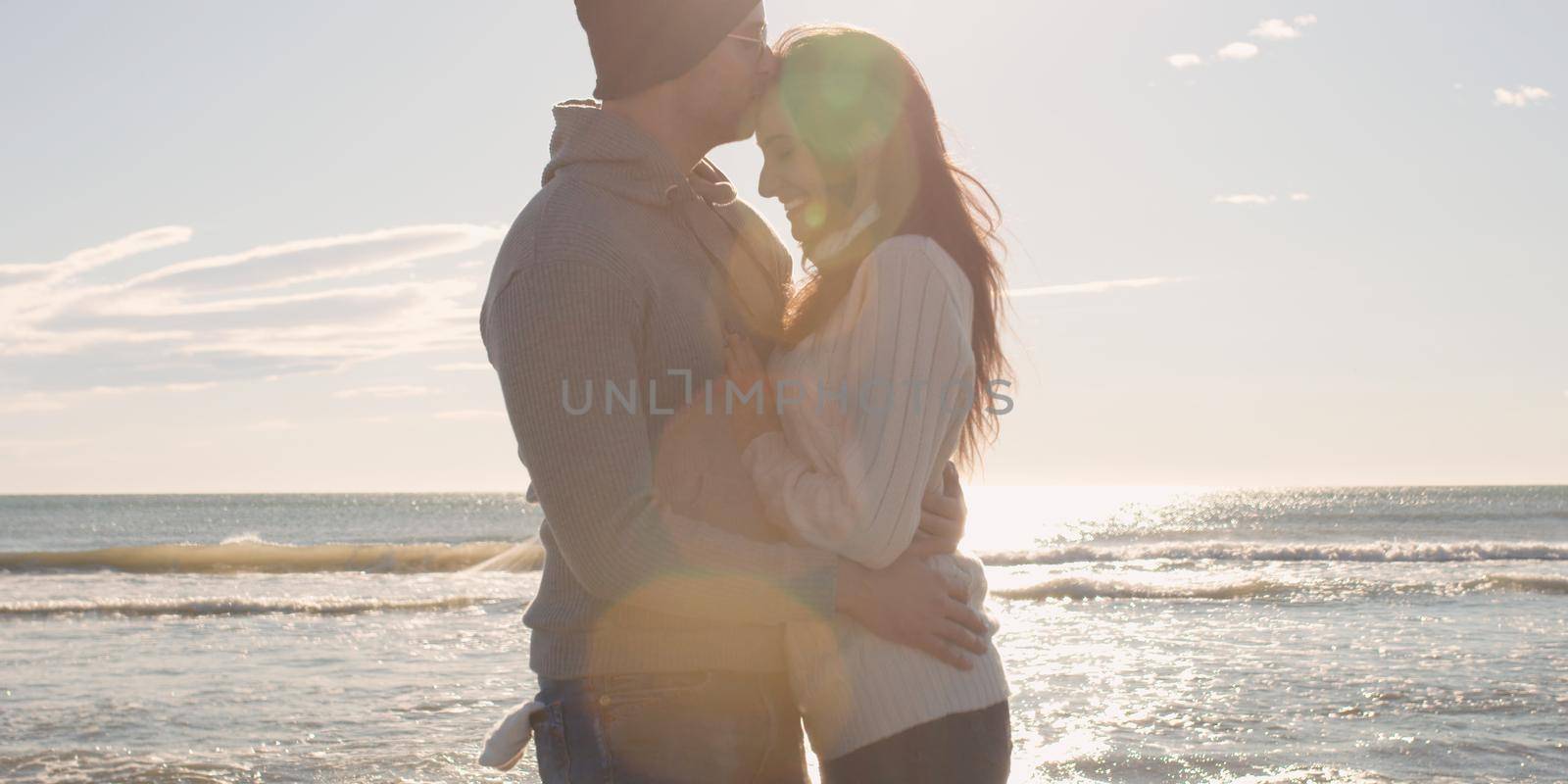 Cool Couple Laughing and hugging In Front Of Beach at beautiful autumn day