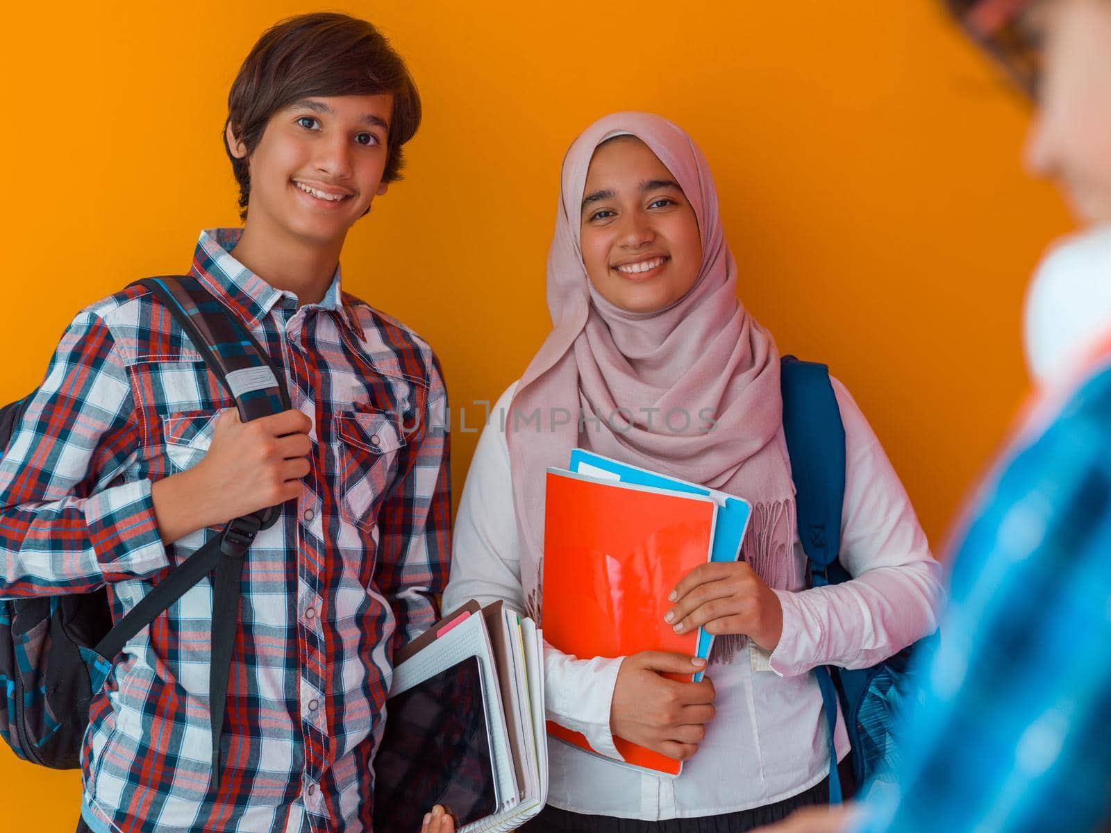A group of Arab teenagers, a student team walking forward into the future and back to school the concept of a yellow background. The concept of successful education for young people. Selective focus. High quality photo