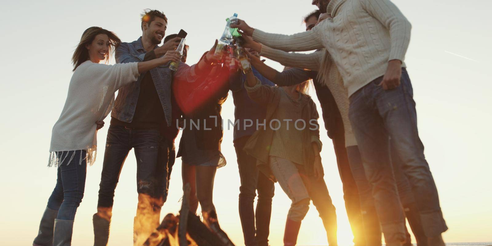 Friends on beach party drinking beer and having fun by dotshock