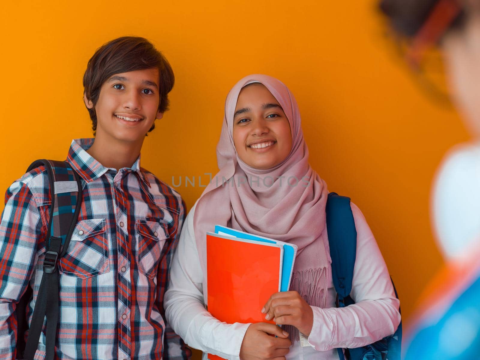 A group of Arab teenagers, a student team walking forward into the future and back to school the concept of a yellow background. The concept of successful education for young people. Selective focus by dotshock