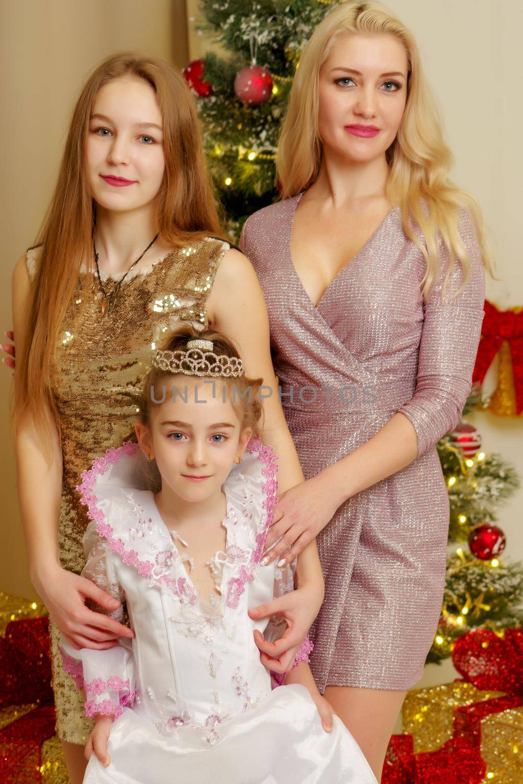 Mom with her daughters near the New Year tree. by kolesnikov_studio