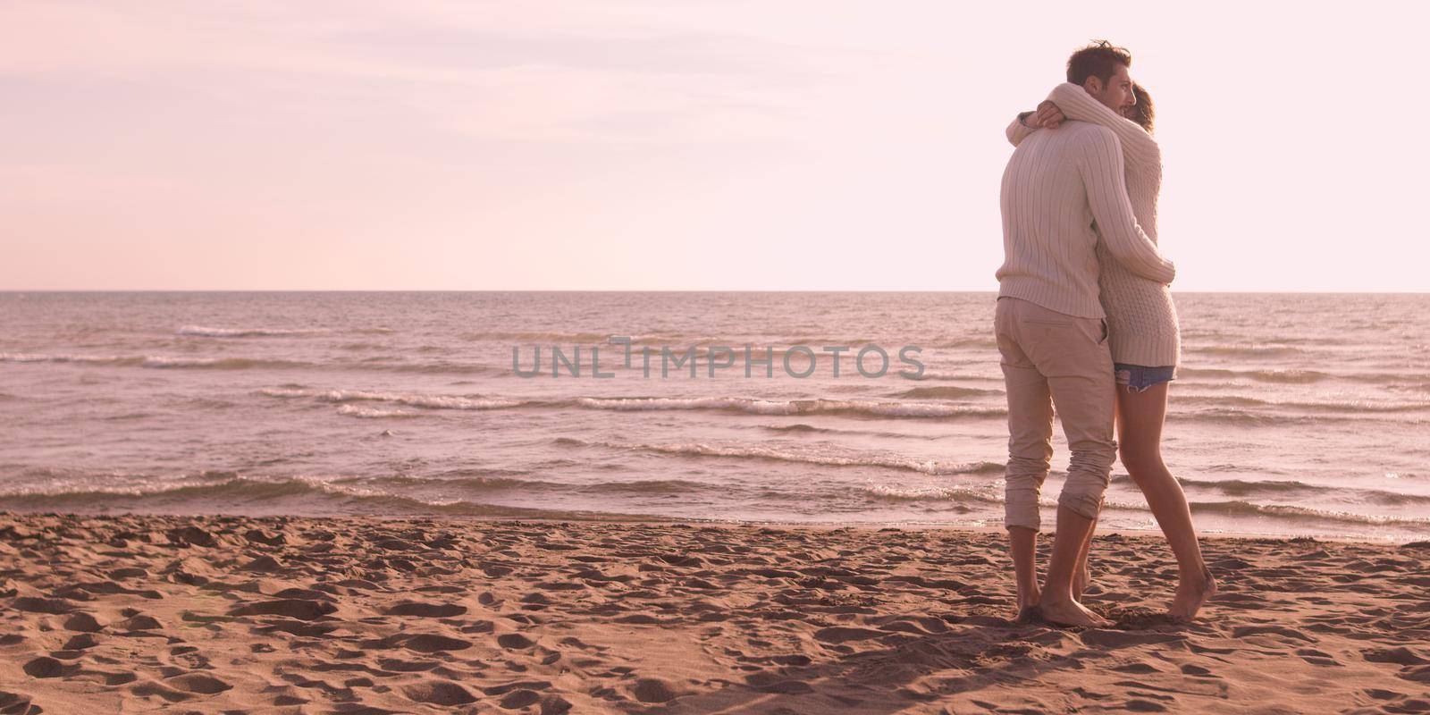 Loving young couple on a beach at autumn on sunny day by dotshock