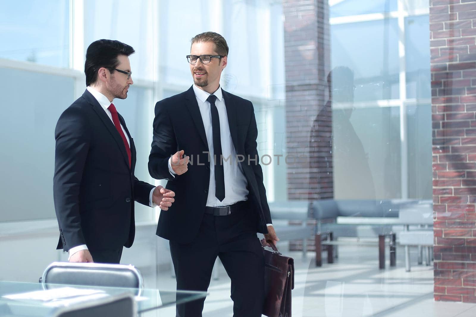 two smiling businessman walking in the office hall.photo with copy space