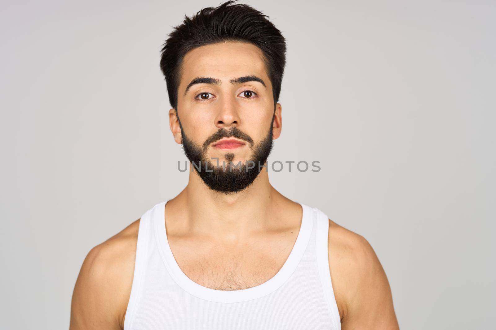 cute bearded man in white studio tank top. High quality photo