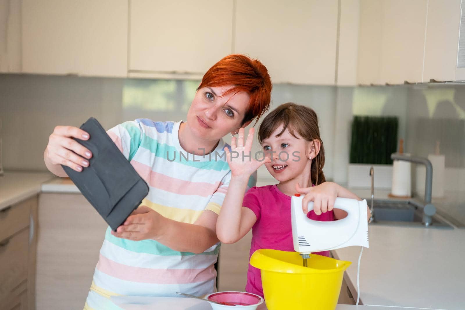 little girl and mom making tastz cake in kithen, family having fun at home 