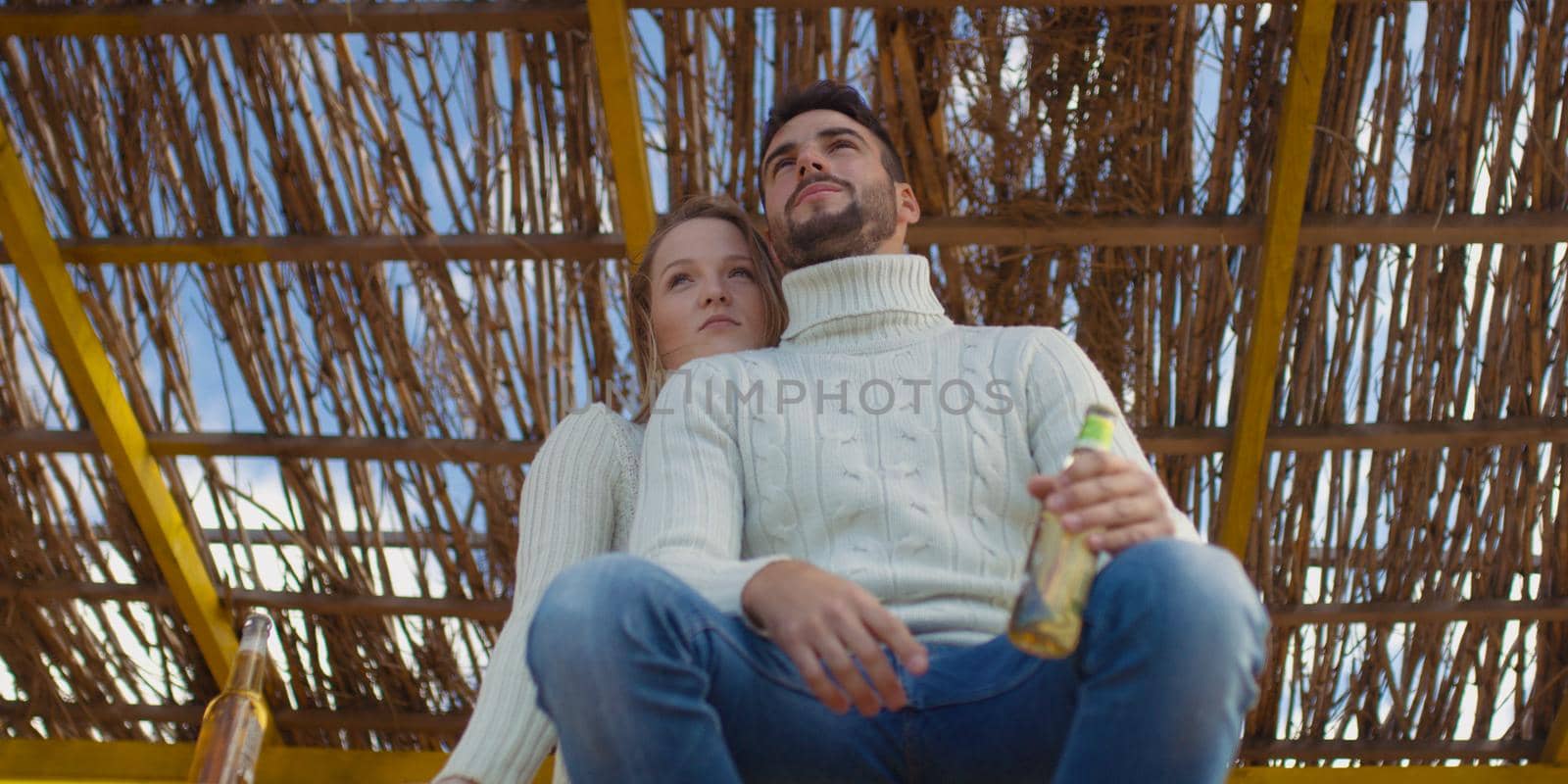 Couple Drinking Beer Together on beach during autumn time