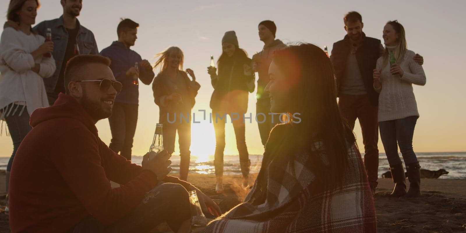 Friends having fun at beach on autumn day by dotshock