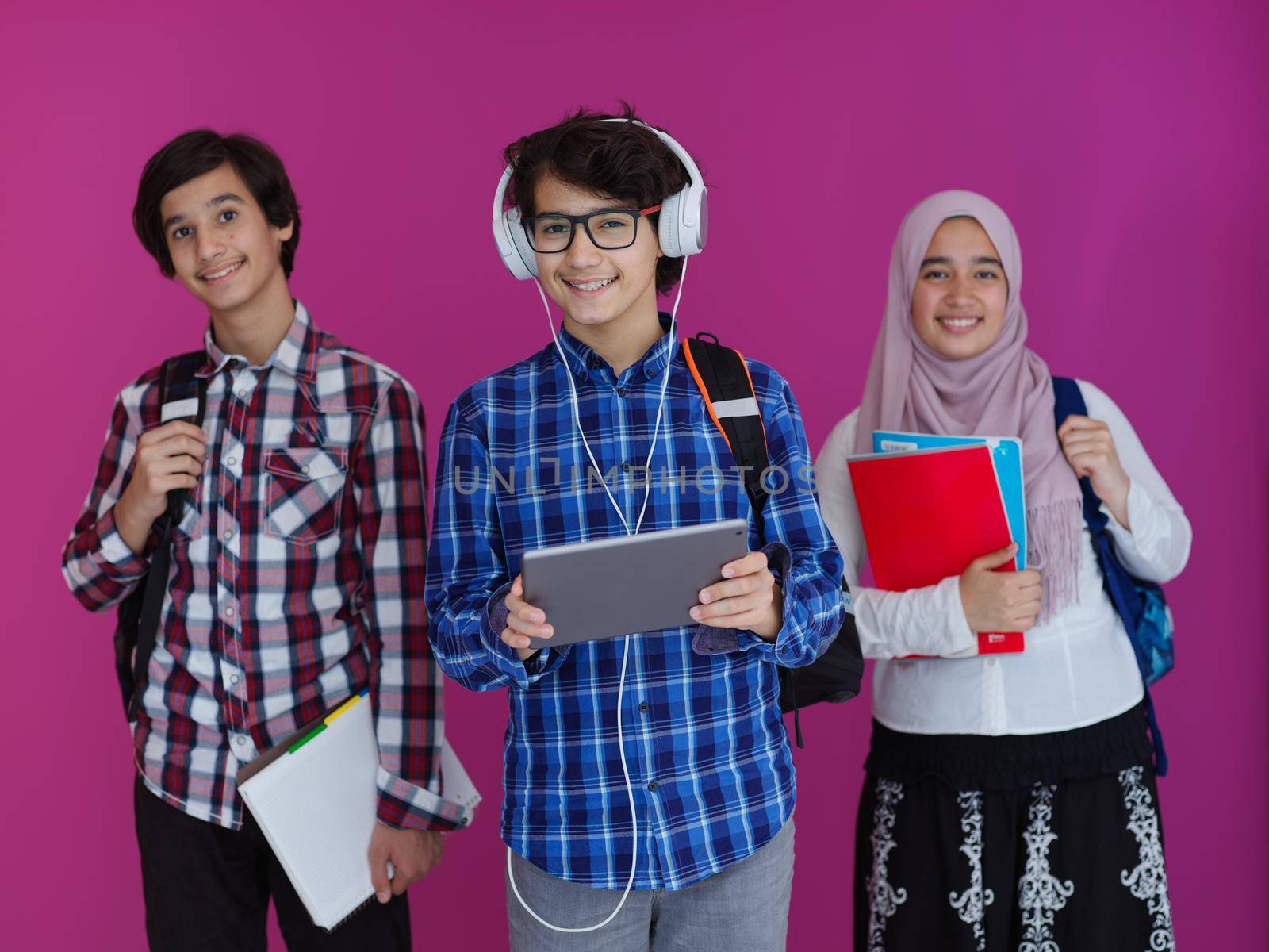 Arabic teenagers as team, students group working together on project using  laptop and tablet computer  online classroom  elearning education concept purple background
