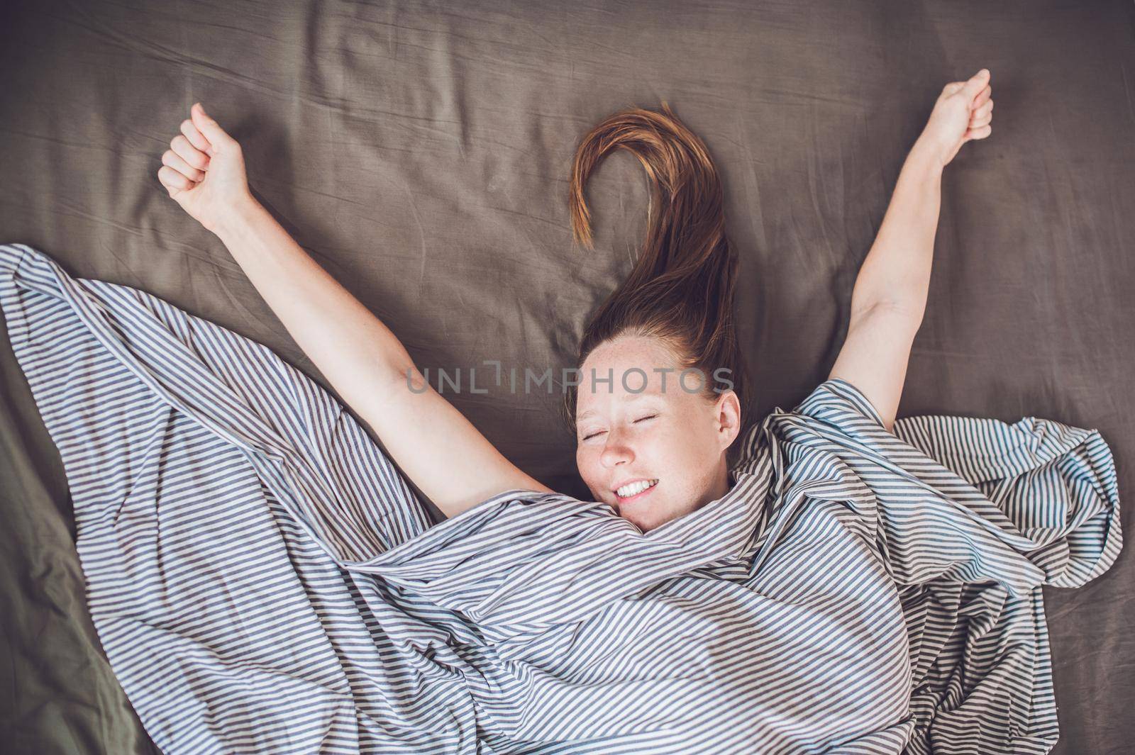 Beautiful young woman lying down in bed and sleeping, top view. Do not get enough sleep concept.