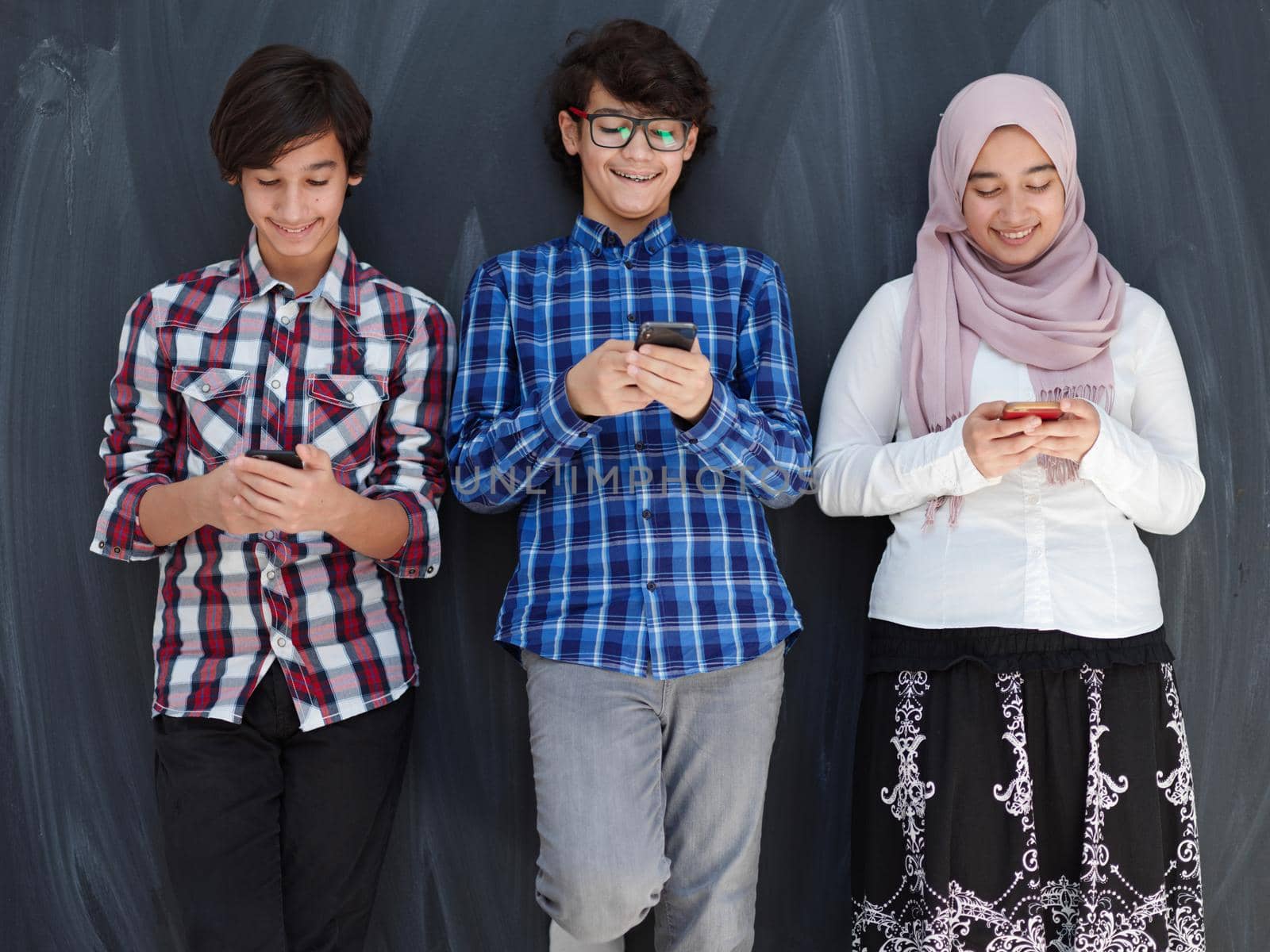 arab teenagers group using smart phones for social media networking by dotshock