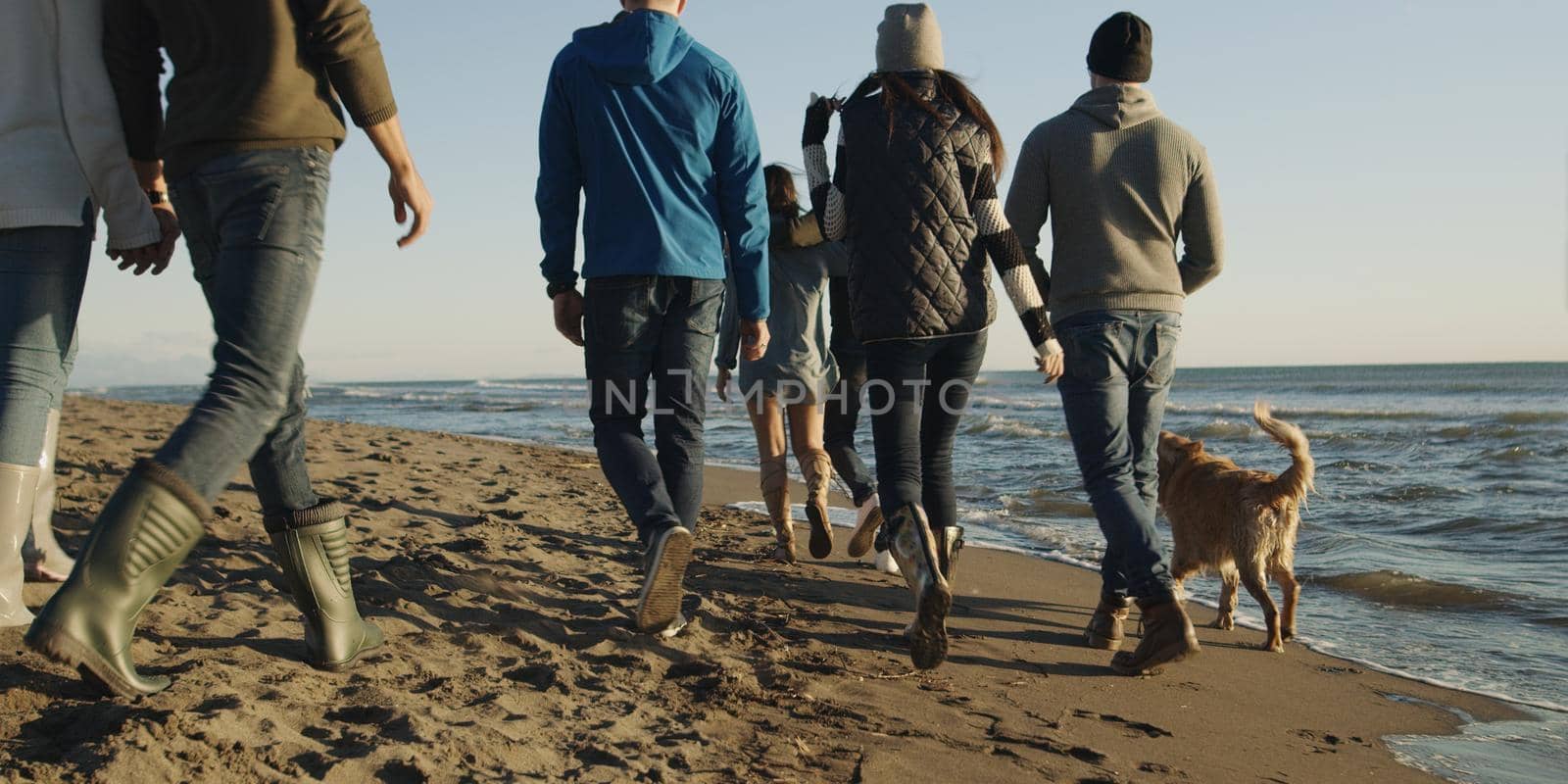 Group Of Young Friends Spending The Day On A Beach during autumn day