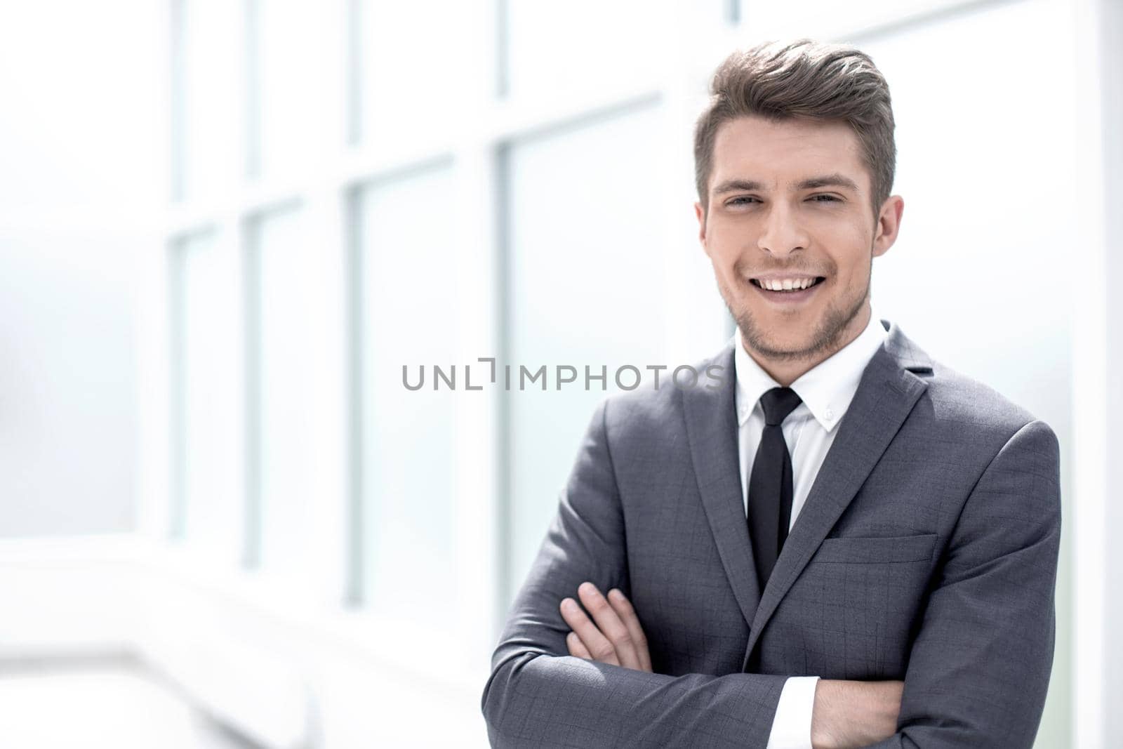 portrait of a businessman standing near the office window.photo with copy space