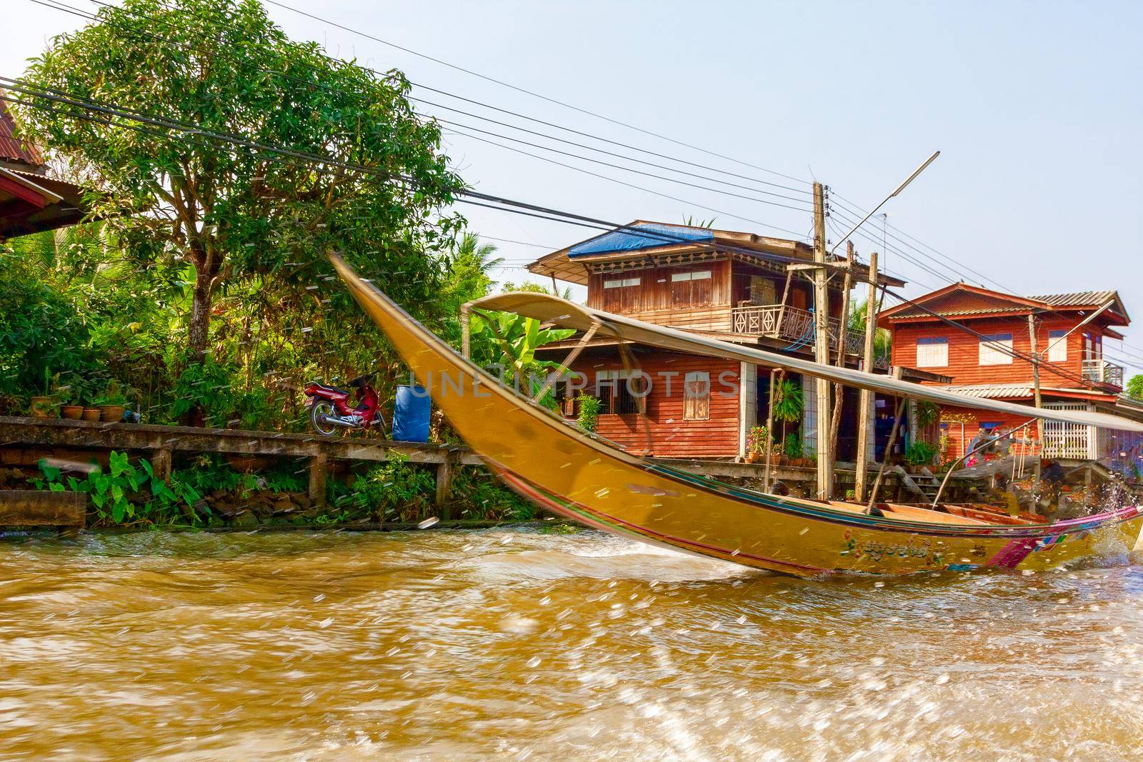 A long tourist boat floats on the River Kwai. Thailand. The concept of tourism, family vacation.