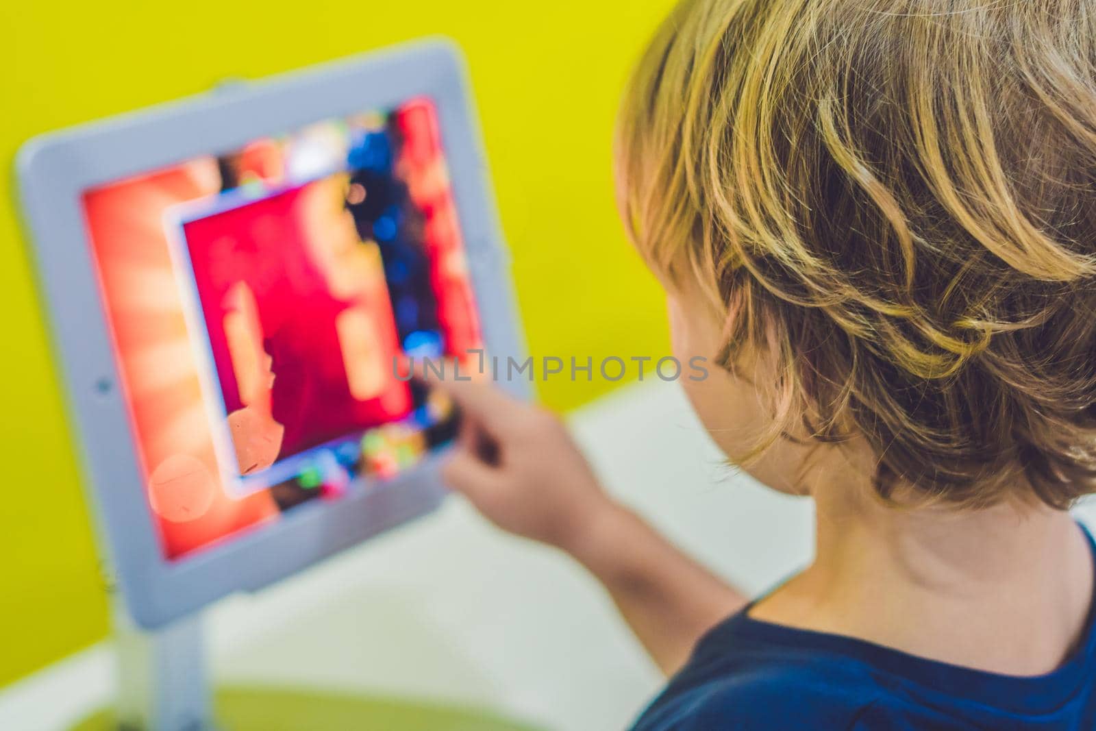 Boy playing with digital tablet. Children and technology concept.