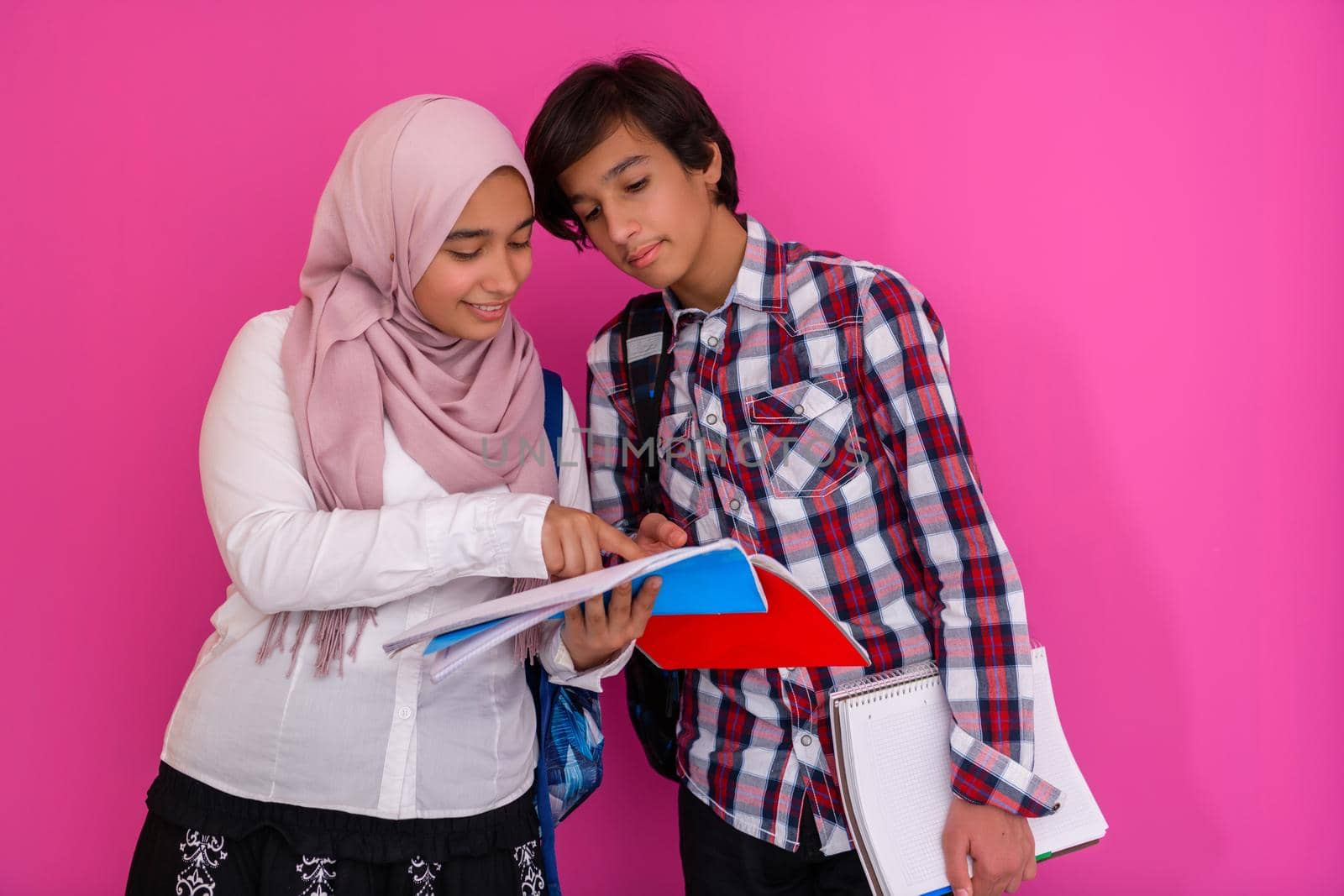 Arabic teenagers group, students team walking forward in future and back to school concept pink background. Selective focus. High quality photo