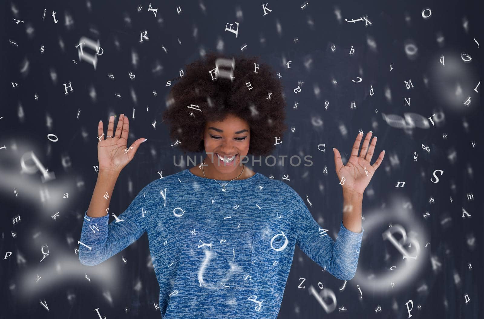 portrait of a beautiful friendly African American woman with a curly afro hairstyle and lovely smile isolated on a gray background