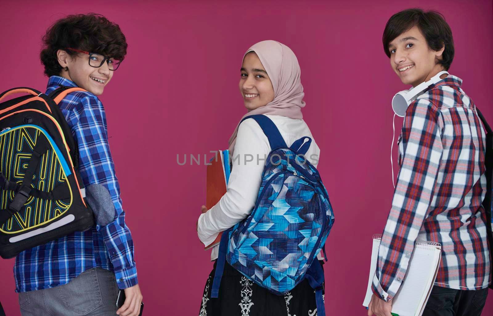 Arabic teenagers group, students team walking forward in future and back to school concept pink background