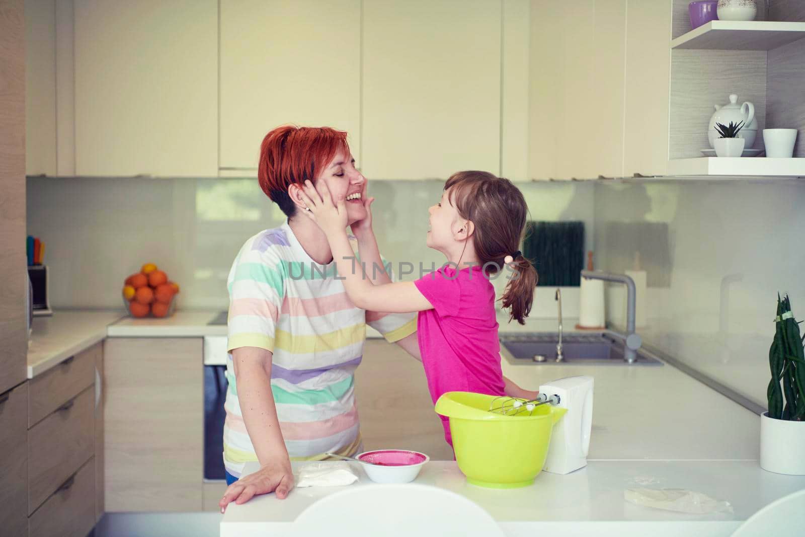 Mother and daughter playing and preparing dough in the kitchen. by dotshock