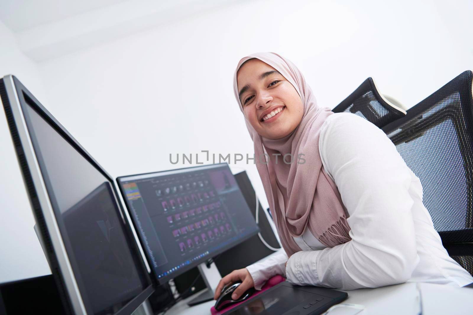 Arabic creative professional  working at home office on desktop computer by dotshock