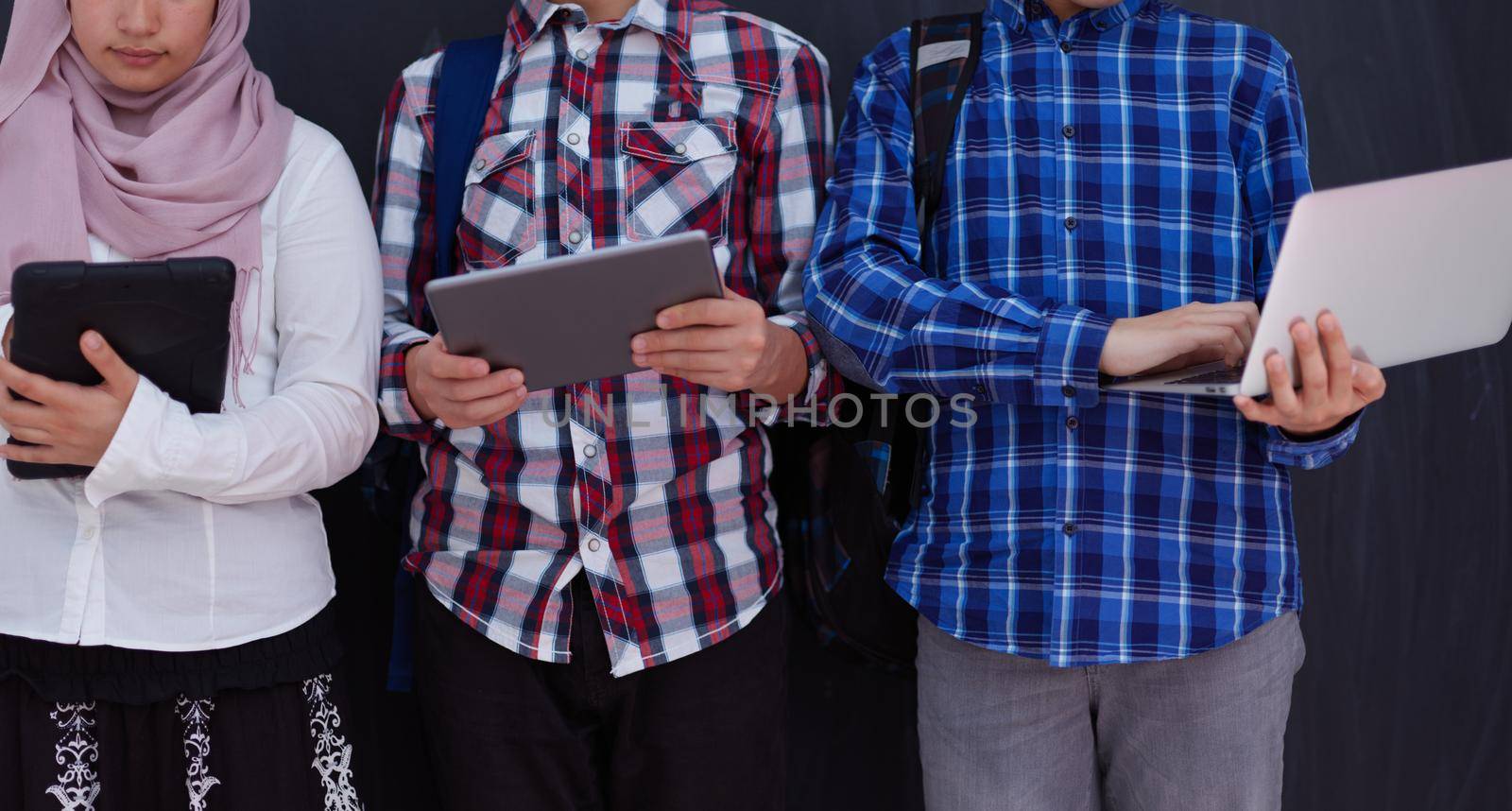 Arab teenagers group working on laptop and tablet computer by dotshock