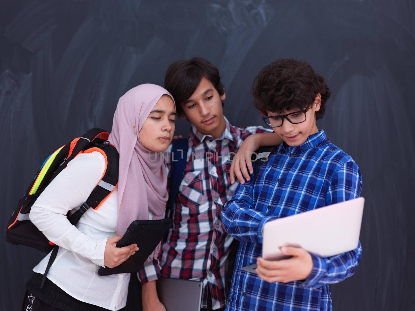 Arab teenagers group working on laptop and tablet computer by dotshock